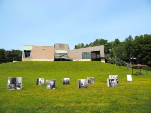 Photos en noir et blanc sur une aire gazonnée devant un musée.  